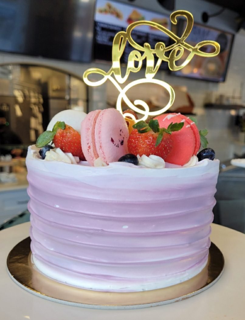Cake topped with extra macarons with love cake topper